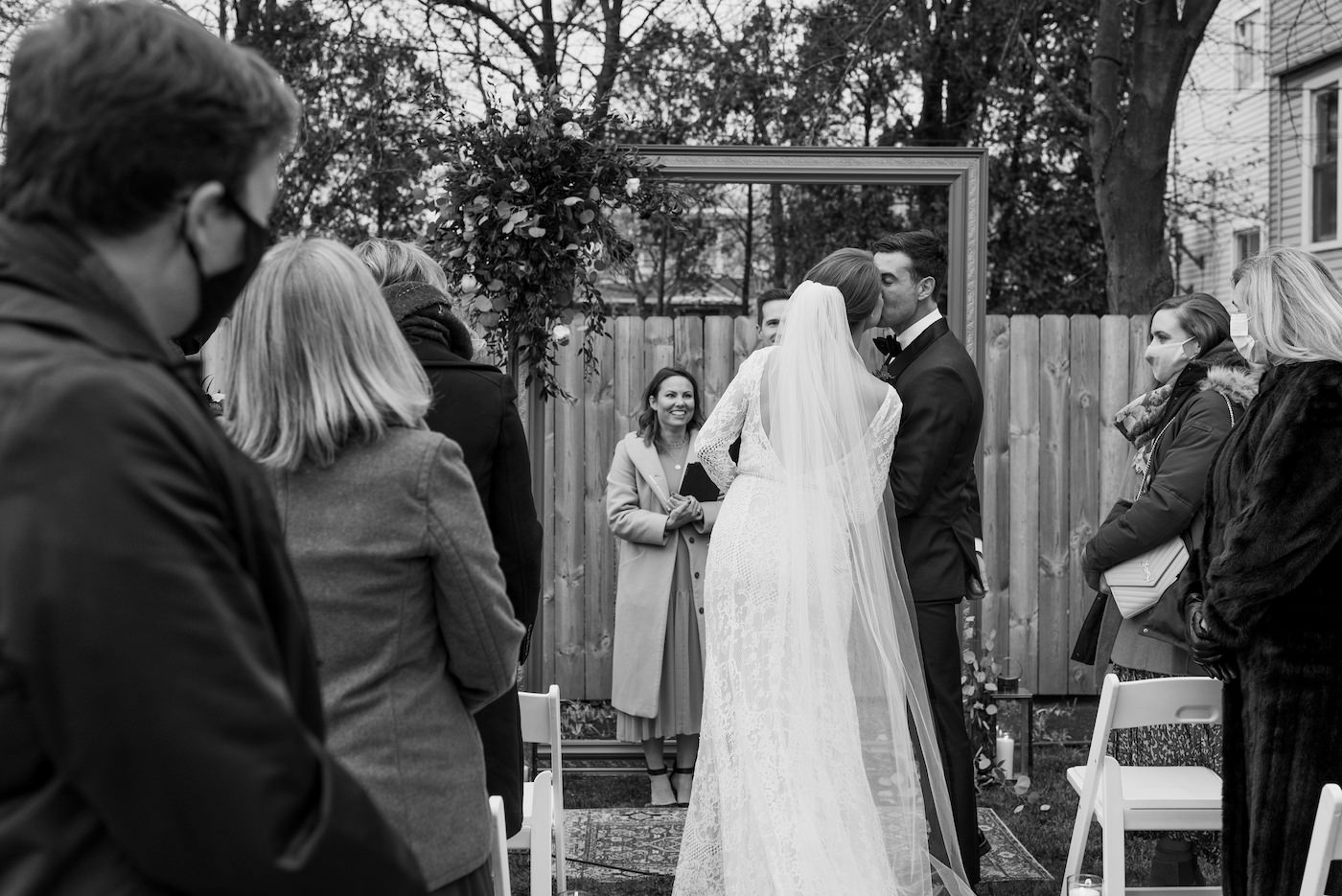 Bride and groom sneak a kiss during their outdoor winter ceremony