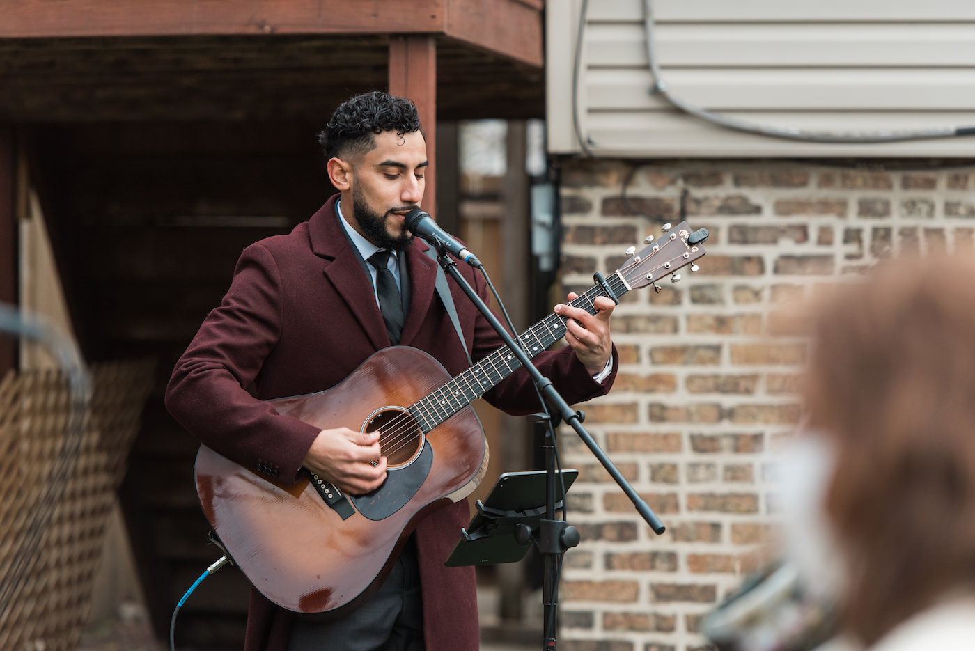 Man plays a guitar during an outdoor wedding ceremony