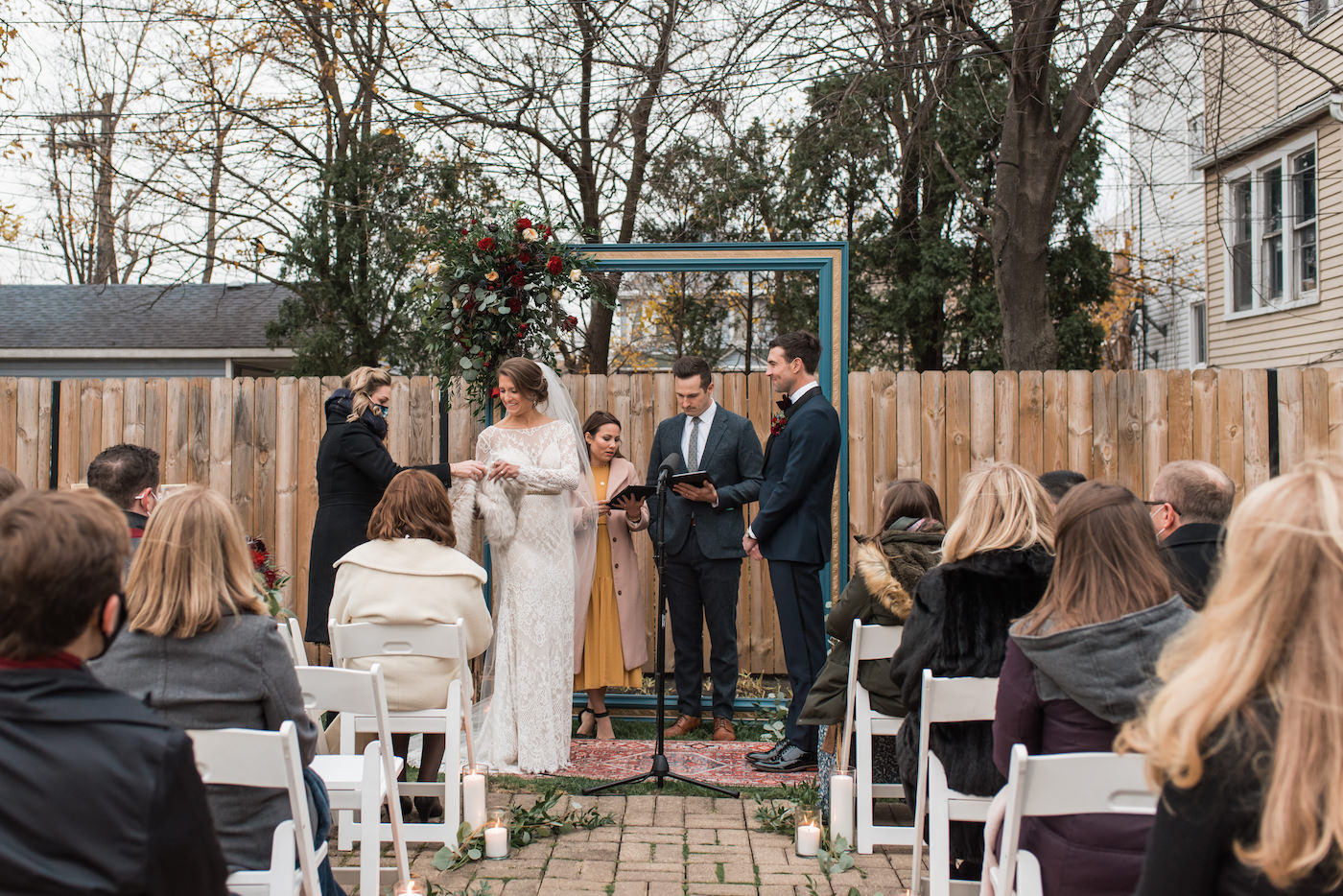 Bride slips into fur stole during outdoor winter wedding