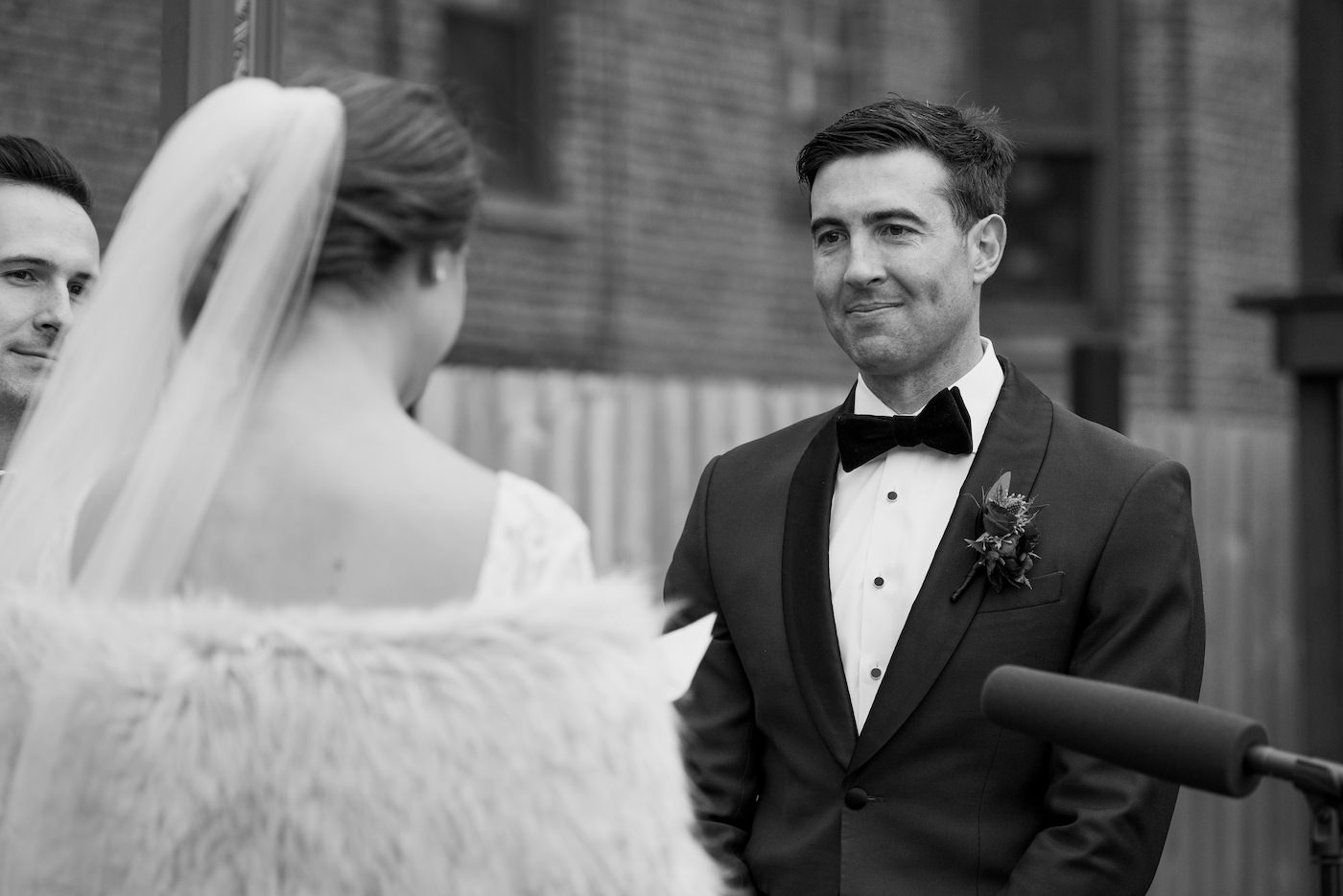 Groom smiling while listening to the Bride's vows