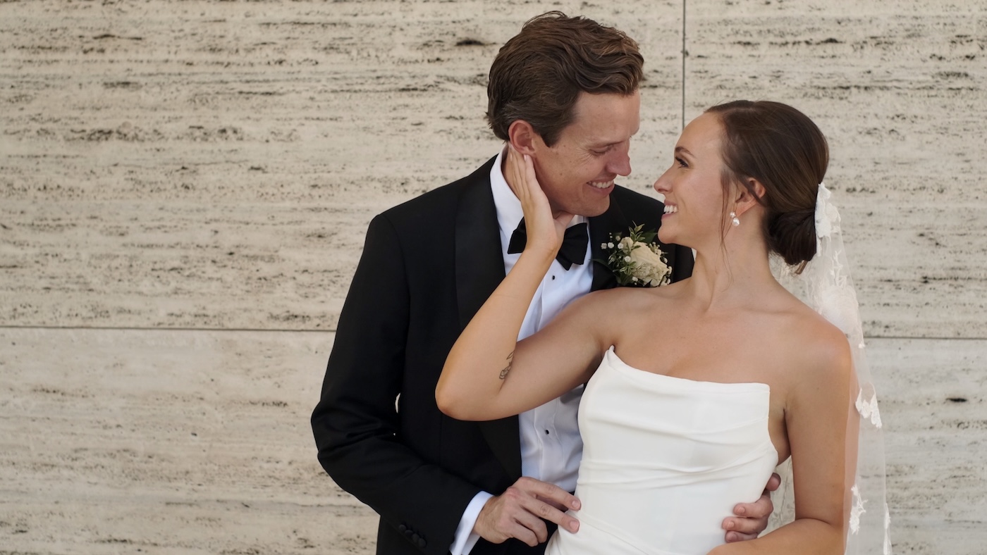 Bride and groom pose for a photo outside The Langham Chicago on their wedding day